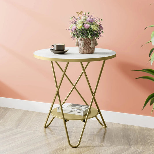 Table basse ronde TavovaT avec plateau en marbre blanc, pieds dorés géométriques et plateau inférieur, décorée d'un vase fleuri et tasse café